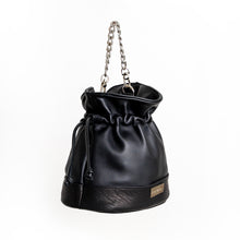 Load image into Gallery viewer, image of black bucket leather handbag, featuring two different lamb leathers, one very soft and one a more grainy leather. This image shows the bag with its chain strap and pulled tight with the drawstring. 
